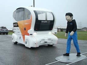 Area XO technical project manager Tandissan Thavathurai moves a life-size figure across a road to test the auto-braking of an autonomous shuttle.