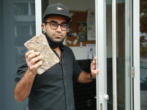 Aditya Budhiraja holds the stone that was used to break the glass door at Les Moulins La Fayette bakery in Ottawa on Tuesday.