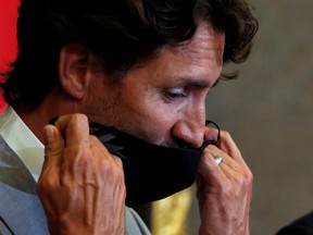Canadian Prime Minister Justin Trudeau removes his mask on Parliament Hill on Aug. 18, 2020.