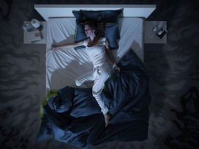 A woman suffering from insomnia and lying in bed late at night.