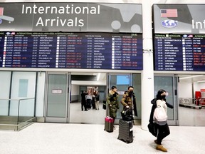 Travellers wear masks at Pearson airport arrivals, shortly after Toronto Public Health received notification of Canada's first presumptive confirmed case of coronavirus, in Toronto, Ontario, Canada January 25, 2020. REUTERS/Carlos Osorio ORG XMIT: GGG-TOR104