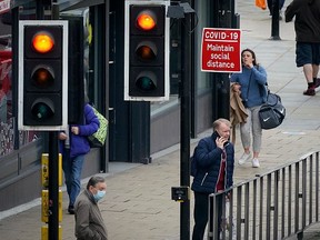 A social distancing sign is affixed next to traffic lights signals on Oct. 8, 2020 in Liverpool, England.