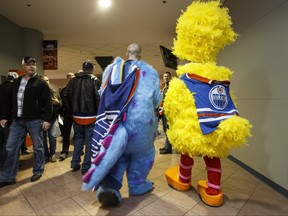 Clint Chatelaine (left) as Sully from Monsters Inc and Matt Harron as Big Bird dressed for Halloween to attend a NHL game between the Edmonton Oilers and the Calgary Flames in Edmonton, Alta. on Saturday October 31, 2015.