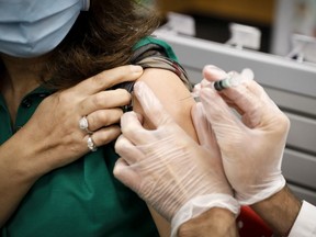 FILE: A pharmacist administers a free flu shot.