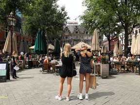 Women wait to sit down outside newly reopened cafes on Leidseplein Square, as Netherlands eases some of the lockdown measures put in place during the coronavirus disease (COVID-19) outbreak, in Amsterdam, Netherlands June 1, 2020.