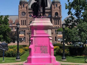 Protesters vandalized the Sir John A. Macdonald statue at Queens Park in Toronto, Ont., on July 18, 2020. The statue is now covered in plastic and hidden behind a wooden structure.