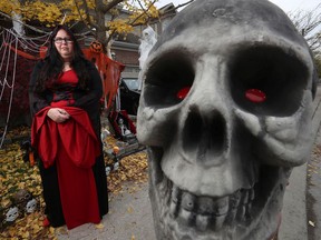 Crystal Smalldon poses for a photo in her yard beside her Halloween decorations in Ottawa. Crystal has organized a Halloween "Spookby" in Kanata, Stittsville and Carp to deliver candy and pick up food bank donations.