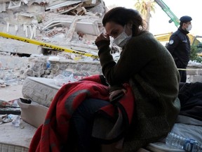 A woman reacts next to debris during rescue operations after an earthquake struck the Aegean Sea, in the coastal province of Izmir, Turkey, October 31, 2020.