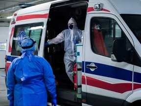 Medical personnel wear protective suits, masks, gloves as they discuss details about a patient who arrived from Warsaw at the SOR of Krakow University Hospital on Nov. 3, 2020 in Krakow, Poland.