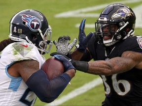 Running back Derrick Henry of the Tennessee Titans stiff arms strong safety Chuck Clark #36 of the Baltimore Ravens in the second half on Sunday.