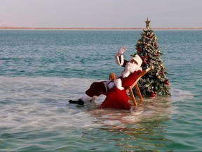 Issa Kassissieh, better known as the Jerusalems Santa Claus, poses next to a Christmas tree on a solid salt formation in the Ein Boqeq Dead Sea resort near Neve Zoha, during the filming of a Christmas season advertisement for the Israeli ministry of tourism, amid the coronavirus pandemic crisis, on Sunday.