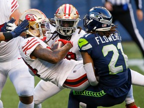 49ers wide receiver Kendrick Bourne (centre) is tackled by Seahawks’ Tre Flowers during Week 8 in Seattle. The status of Sunday’s San Francisco-Green Bay game is in question after Bourne reportedly tested positive for COVID-19.
