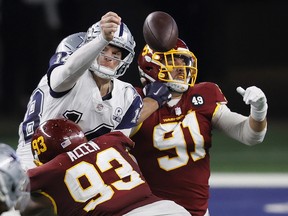 Cowboys quarterback Andy Dalton is pressured by Washington’s Jonathan Allen and Ryan Kerrigan during Thursday night'’s game in Arlington, Texas.