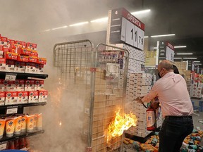 People put out a fire at a vandalized store as demonstrators protest against the death of Joao Alberto Silveira Freitas, a Black man beaten to death at a market in Porto Alegre, Brazil, November 20, 2020.