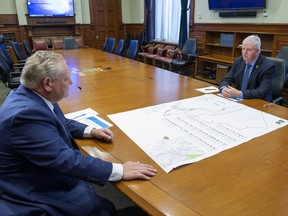 Premier Doug Ford and former head of the Canadian Armed Forces Gen. Rick Hillier look over a map in the premier's office at the Ontario Legislature in Toronto on Friday, Nov. 27, 2020. Hillier will lead a new task force that will oversee the rollout of the COVID-19 vaccine in the province.
