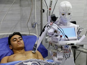 A volunteer is examined by Cira 3, a remote-controlled robot that runs tests on suspected coronavirus patients to limit the human exposure to the virus in Tanta, Egypt, November 18, 2020.