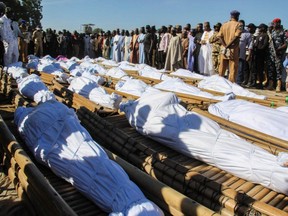 Mourners attend the funeral of 43 farm workers in Zabarmari, about 20 km from Maiduguri, Nigeria, on Sunday, Nov. 29, 2020, after they were killed by Boko Haram fighters in rice fields near the village of Koshobe on Saturday.