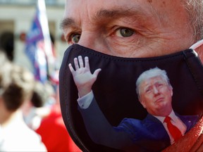 Doug Roman wearing a U.S. President Donald Trump protective mask takes part in a protest against the results of the 2020 U.S. presidential election in Atlanta, Ga., Nov. 21, 2020.