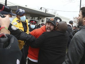 Adamson BBQ owner Adam Skelly is led away from his restaurant just after noon time by Toronto Police. Protestors and supporters tried to wrestle him away from police as they brought him to an awaiting cruiser on Royal York Blvd. on Thursday November 26, 2020.