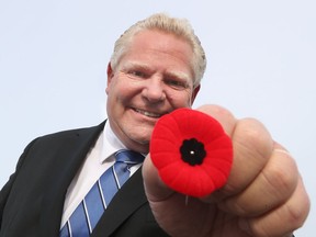Premier Doug Ford holding a poppy after his briefing at the Ottawa Civic Hospital in Ottawa Friday, Nov. 6, 2020.