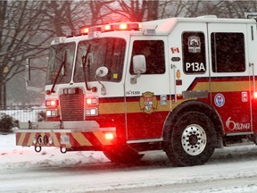An Ottawa fire truck heads to an emergency call during snowy conditions in Ottawa on Wednesday.