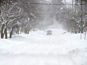 A lone truck makes its way along a snowy road in Owen Sound, Ont., Feb. 28, 2020.