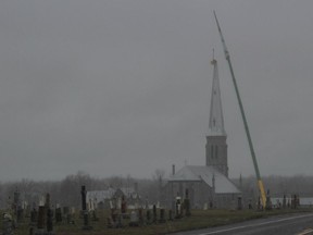Work is done to install a new steeple at St. Andrews Catholic Church on Wednesday.