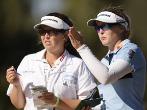 Brooke Henderson, right, talks with her sister and caddy, Brittany Henderson, on the 17th hole during the third round of the CME Group Tour Championship at North Naples, Fla., on Saturday.