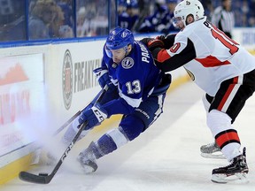Cedric Paquette #13 of the Tampa Bay Lightning and Tom Pyatt #10 of the Ottawa Senators fight for the puck during a game  at Amalie Arena on March 13, 2018 in Tampa, Florida.