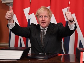 Prime Minister Boris Johnson gives a thumbs up gesture after signing the Brexit trade deal with the EU in Number 10 Downing Street on December 30, 2020 in London.