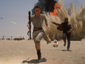 This photo provided by Disney shows Daisey Ridley as Rey, left, and John Boyega as Finn, in a scene from the film, "Star Wars: The Force Awakens," directed by J.J. Abrams.