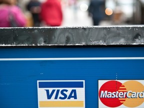 Visa and MasterCard credit card logos are seen in a store window in Washington on March 30, 2012.