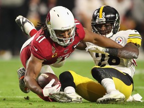 Cardinals wide receiver Larry Fitzgerald makes a reception ahead of Steelers cornerback Mike Hilton. Fitzgerald is feeling much better after beating COVID-19.
