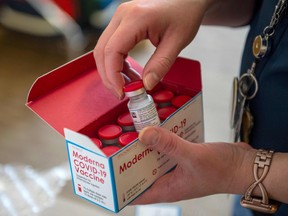 A nurse unpacks a special refrigerated box of Moderna COVID-19 vaccines as she prepared to ready more supply for use at the East Boston Neighborhood Health Center (EBNHC) in Boston on Dec. 24, 2020.