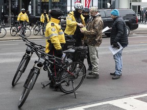 A supporter of 'The Line Canada' speaks to police after they issued a summons to appear under the 'Reopening Ontario Act' after an anti-lockdown rally to protest in Toronto on Saturday December 19, 2020.