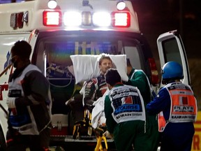 Medics attend to Haas F1's French driver Romain Grosjean after a crash at the start of the Bahrain Grand Prix at the Bahrain International Circuit in the city of Sakhir, Sunday, Nov. 29, 2020.