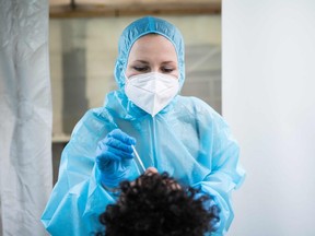 Files: One employee wearing PPE takes a swab to test for the Covid-19 coronavirus on a patient