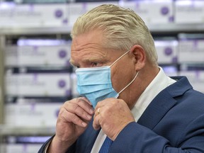 Ontario Premier Doug Ford puts his mask back on during the daily briefing at Humber River Hospital in Toronto on Tuesday, Nov. 24, 2020.