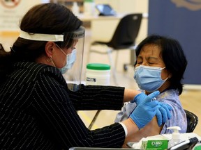 A healthcare worker administers a Pfizer/BioNTEch coronavirus disease (COVID-19) vaccine to personal support worker Anita Quidangen at The Michener Institute, in Toronto, Canada December 14, 2020.