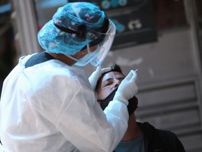 A medical team member takes a swab sample from a man to be tested for the coronavirus disease (COVID-19).