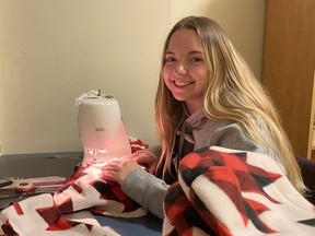 Emma Weller sews mittens in her residence room at Carleton University.