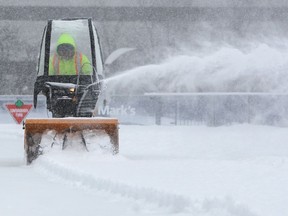 FILE: A worker clears snow.