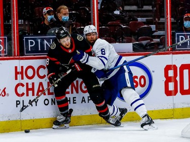 Senators right-winger Connor Brown (28) battles Maple Leafs defenceman Jake Muzzin for position along the boards behind the Toronto net.