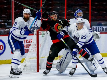 Senators centre Derek Stepan battles with Maple Leafs defencemen Jake Muzzin and Travis Dermott (23) in front of goaltender Frederik Andersen.