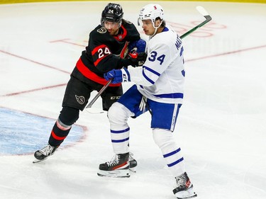 Senators defenceman Christian Wolanin (24) checks Maple Leafs centre Auston Matthews.