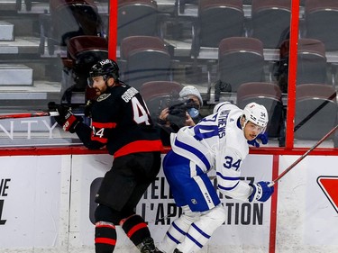 Senators defenceman Erik Gudbranson (44) checks Maple Leafs center Auston Matthews.