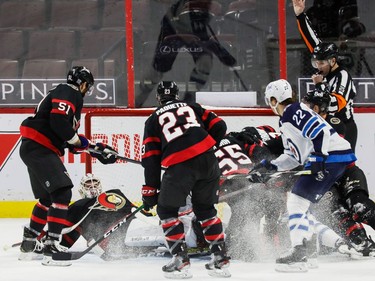 Senators teammates surround goaltender Matt Murray and help keep the puck out of the net during a scramble in the first period of Tuesday's game against the Jets.