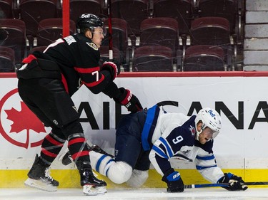 Senators left-winger Brady Tkachuk (7) checks Jets centre Andrew Copp in the first period.