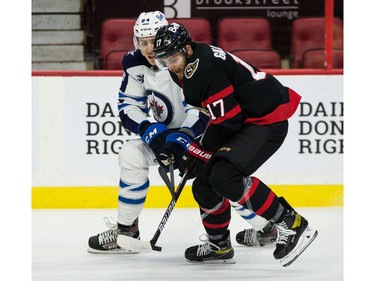 Senators forward Alex Galchenyuk (17) battles for a loose puck with the Jets' Logan Stanley during first-period play on Tuesday night.
