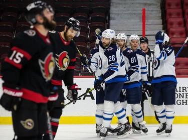 Jets players celebrate a second-period goal by Kyle Connor (81) against the Senators on Tuesday night.